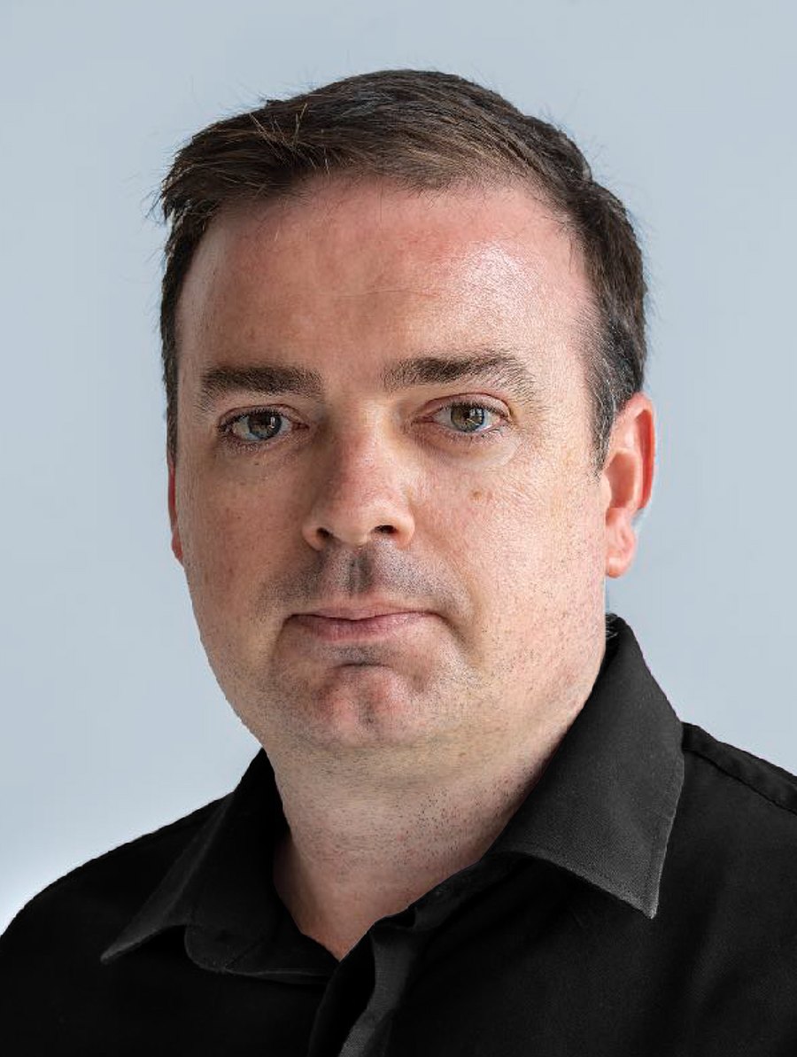 Retrato de David Vivancos con camisa negra sobre fondo claro.