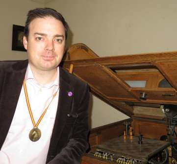 David Vivancos, con una medalla, sentado junto al Ajedrecista original.